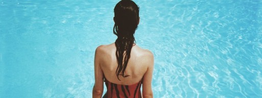 woman sitting by swimming pool