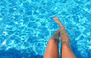 A woman's legs dipped into a pool