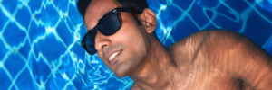 tanned man floats in his new pool wearing sunglasses