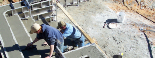 workers from Poolarama build stairs for an inground swimming pool