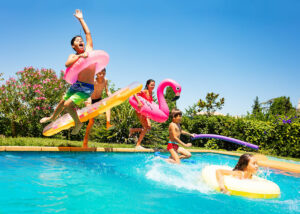 kids jumping into the pool and having fun in the summer