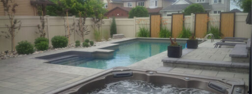 A backyard with a pool and a spa. Also is furnished, with houses in the background